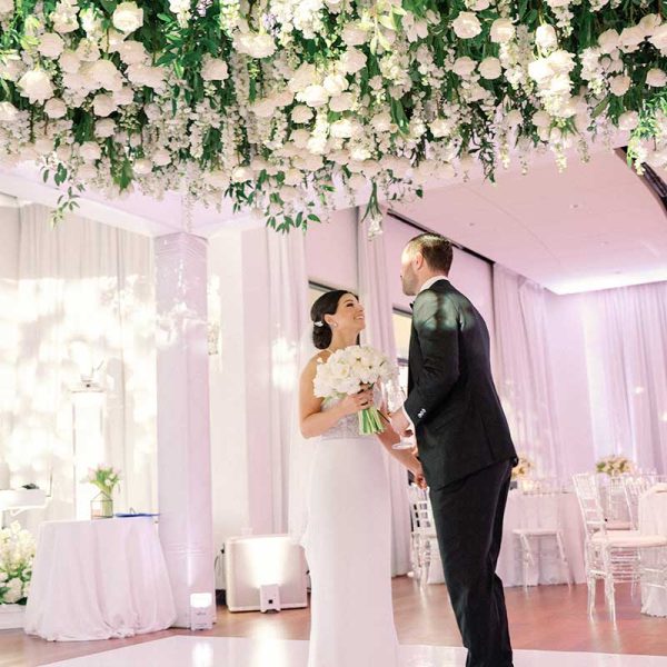 Newlyweds at wedding reception with table rentals and clear Chiavari chair rentals from Niche Event Rentals | Trenholm Photo