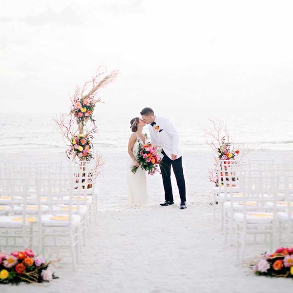 Couple kissing after wedding ceremony with white Chiavari chair rentals from Niche Event Rentals | Maria Glassford Photo