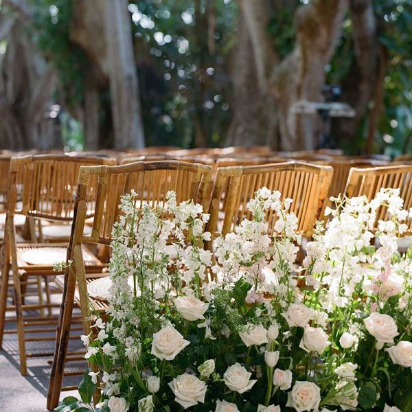 Wedding ceremony with white florals and folding chair rentals | Carrie Patterson Photography | Niche Event Rentals